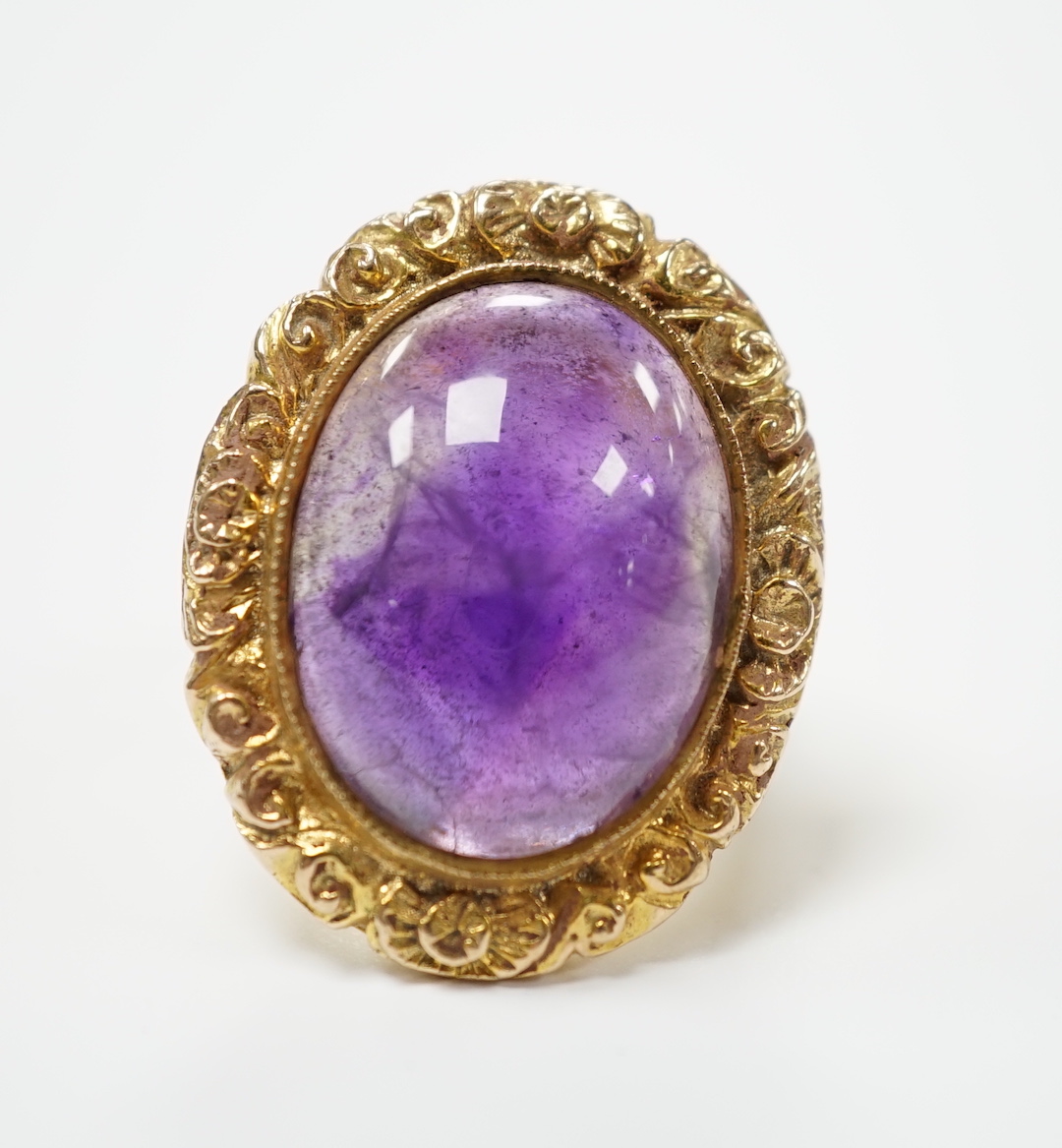 A 1970's Victorian style 9ct gold and cabochon amethyst set oval dress ring, size J, gross weight 13.1 grams.